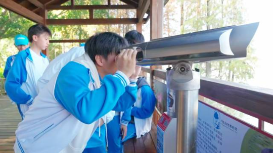 科普研学游中,学生们正在用望远镜观鸟 科普研学游中,学生们正在用望远镜观鸟